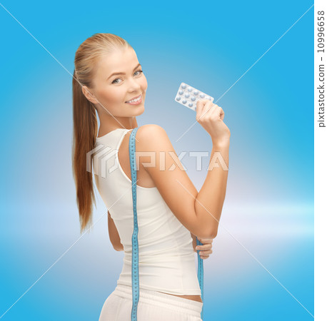 smiling woman with measuring tape and diet pills smiling woman with measuring tape and diet pills 10996658