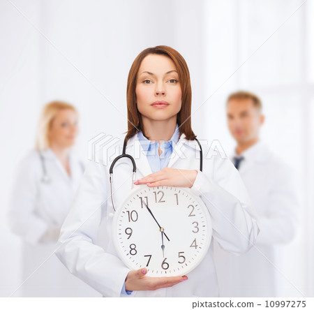 calm female doctor with wall clock calm female doctor with wall clock 10997275