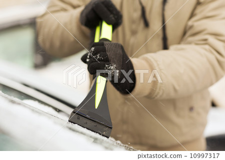 closeup of man scraping ice from car 10997317