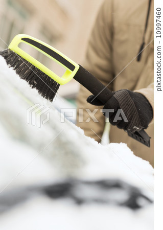 closeup of man cleaning snow from car closeup of man cleaning snow from car 10997460