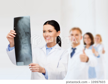 smiling female doctor looking at x-ray smiling female doctor looking at x-ray 10997603