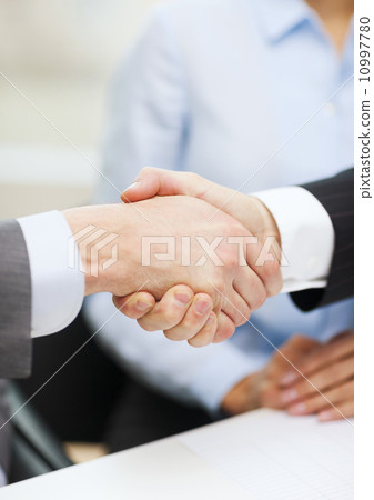 two businessmen shaking hands in office two businessmen shaking hands in office 10997780
