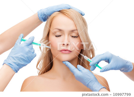 woman face and beautician hands with syringes 10997799