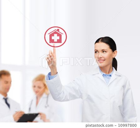 smiling female doctor pointing to hospital sign 10997800