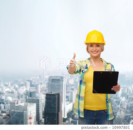 smiling woman in helmet with clipboard 10997801