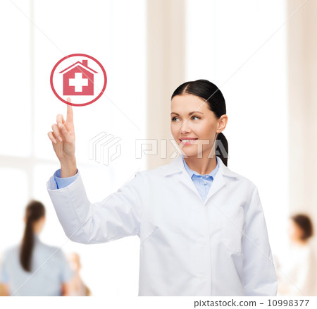 smiling female doctor pointing to hospital sign 10998377