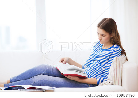 calm teenage girl reading book on couch calm teenage girl reading book on couch 10998486