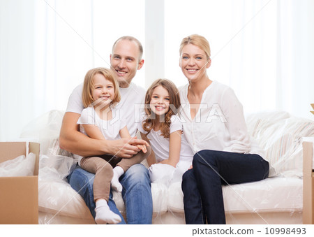 smiling parents and two little girls at new home smiling parents and two little girls at new home 10998493