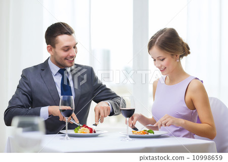 smiling couple eating main course at restaurant smiling couple eating main course at restaurant 10998659