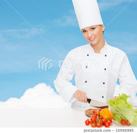 smiling female chef chopping vagetables smiling female chef chopping vagetables 10998995