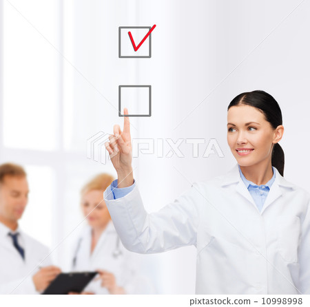 smiling female doctor pointing checkbox smiling female doctor pointing checkbox 10998998