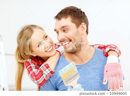 smiling couple covered with paint with paint brush smiling couple covered with paint with paint brush 10999005