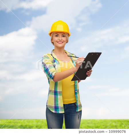 smiling woman in helmet with clipboard 10999076