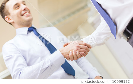 two businessmen shaking hands in office two businessmen shaking hands in office 10999152