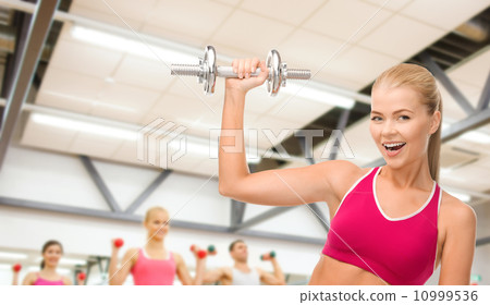 smiling woman with heavy steel dumbbell smiling woman with heavy steel dumbbell 10999536