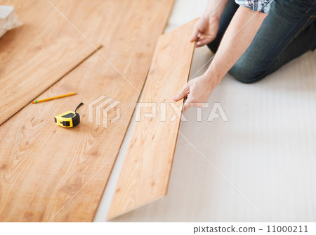 close up of male hands intalling wood flooring 11000211
