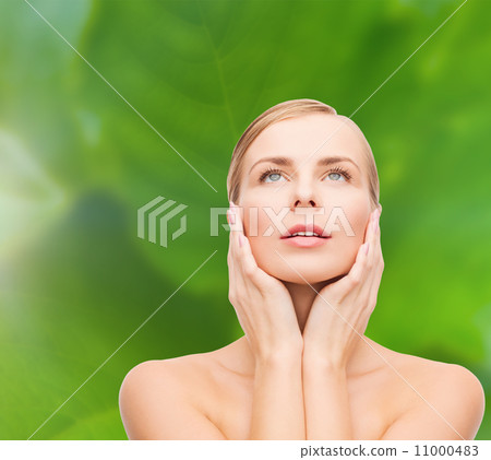 beautiful woman touching her face and looking up beautiful woman touching her face and looking up 11000483