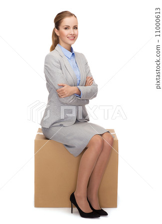 smiling woman sitting on cardboard box 11000613