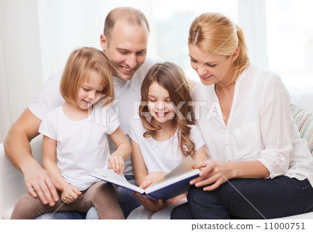 smiling family and two little girls with book 11000751