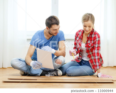 smiling couple measuring wood flooring smiling couple measuring wood flooring 11000944