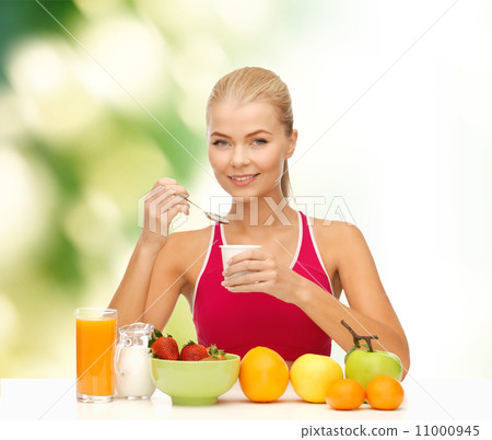 young woman eating healthy breakfast young woman eating healthy breakfast 11000945