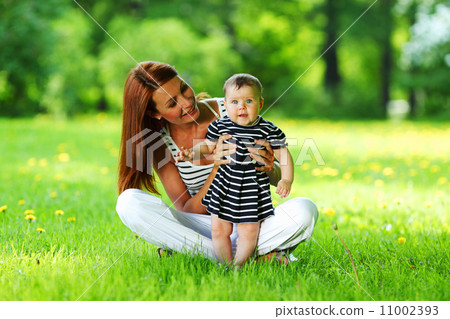 Mother and daughter on the green grass Mother and daughter on the green grass 11002393