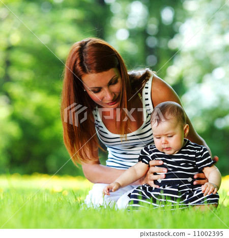 Mother and daughter on the green grass Mother and daughter on the green grass 11002395