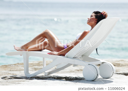 Woman in chaise-lounge near sea 11006024