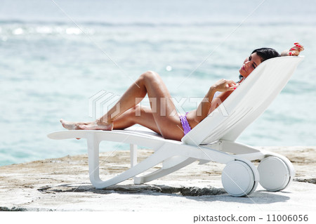 Woman in chaise-lounge near sea 11006056