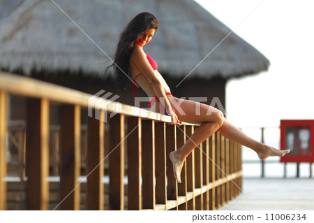 Woman in bikini near tropical hotel Woman in bikini near tropical hotel 11006234
