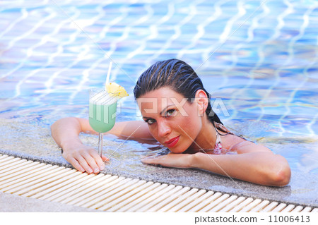Woman in swimming pool with cocktail 11006413