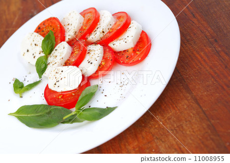 Mozzarella cheese tomato and basil on a plate Mozzarella cheese tomato and basil on a plate 11008955