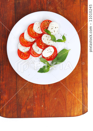 Mozzarella cheese tomato and basil on a plate 11010245