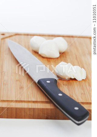 Sliced mozzarella with knife on wooden board Sliced mozzarella with knife on wooden board 11010351