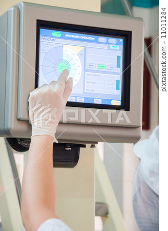 industrial worker pointing the finger to the machine monitoring control panel display 11011284