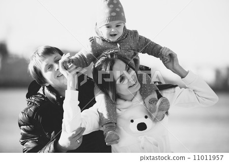 Parents playing with small daughter at beach Parents playing with small daughter at beach 11011957
