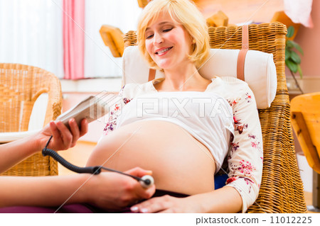 Midwife seeing mother for pregnancy examination 11012225
