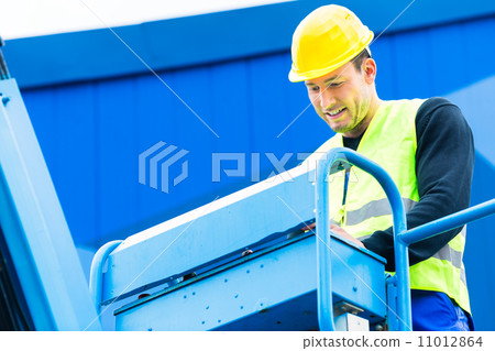 Crane driver driving hydraulic lifting ramp with control desk Crane driver driving hydraulic lifting ramp with control desk 11012864