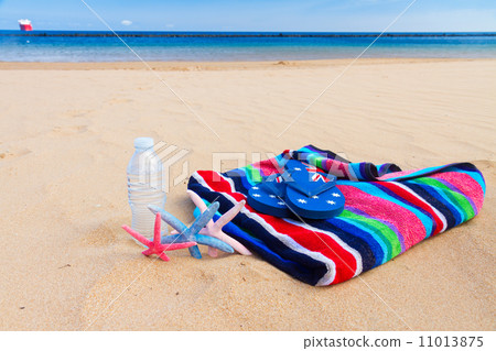 beach towel and bottle of water on sandy beach 11013875