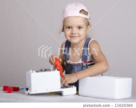 Girl repairs screwdriver toy microwave Girl repairs screwdriver toy microwave 11020360