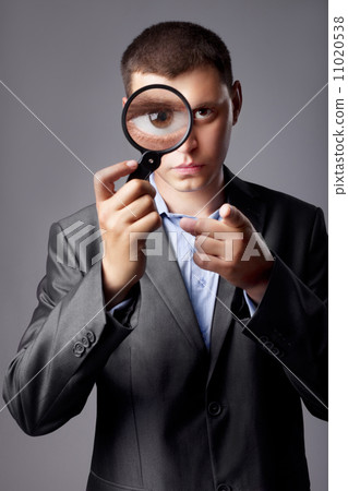 businessman in a suit looking through a magnifying glass 11020538