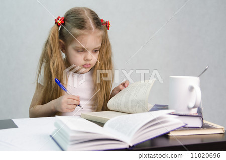 Girl leafing through book and wrote on a sheet of paper abstract sitting 11020696
