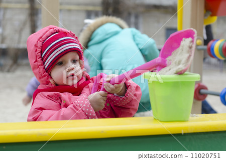 little girl pours sand bucket in sandbox little girl pours sand bucket in sandbox 11020751