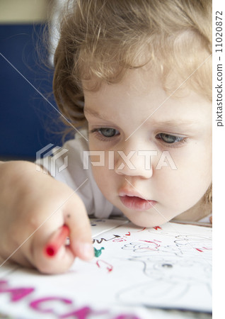 Girl draws a pencil on sheet of paper Girl draws a pencil on sheet of paper 11020872