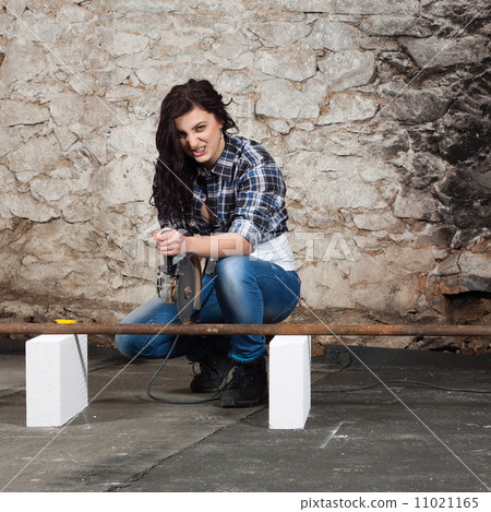 Young long-haired woman with an angle grinder 11021165