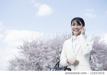 從站立在櫻桃樹前面的一名新的僱員的一名婦女 從站立在櫻桃樹前面的一名新的僱員的一名婦女 11021818
