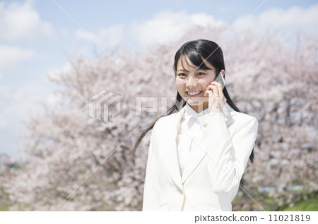 從站立在櫻桃樹前面的一名新的僱員的一名婦女 從站立在櫻桃樹前面的一名新的僱員的一名婦女 11021819