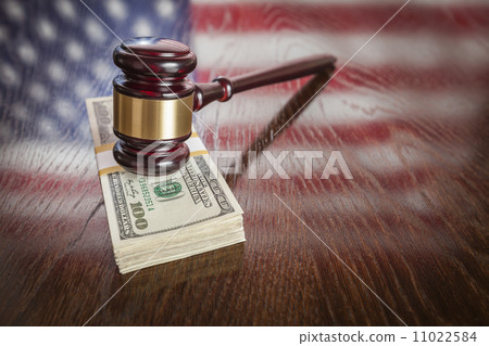 Wooden Gavel Resting on Money with American Flag Reflection 11022584