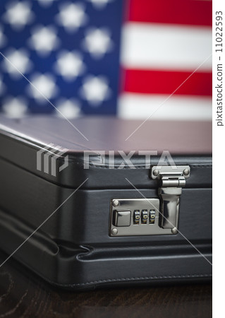 Leather Briefcase Resting on Table with American Flag Behind 11022593