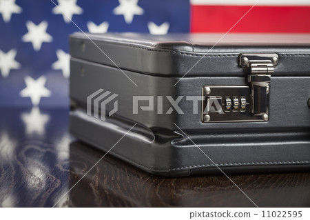 Leather Briefcase Resting on Table with American Flag Behind 11022595